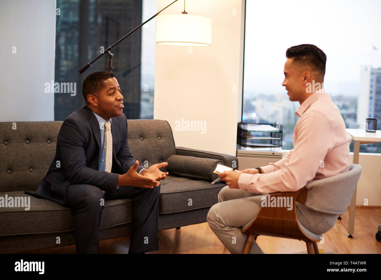 Unternehmer Sitzen auf der Couch treffen mit männlichen Ratgeber in Office Stockfoto