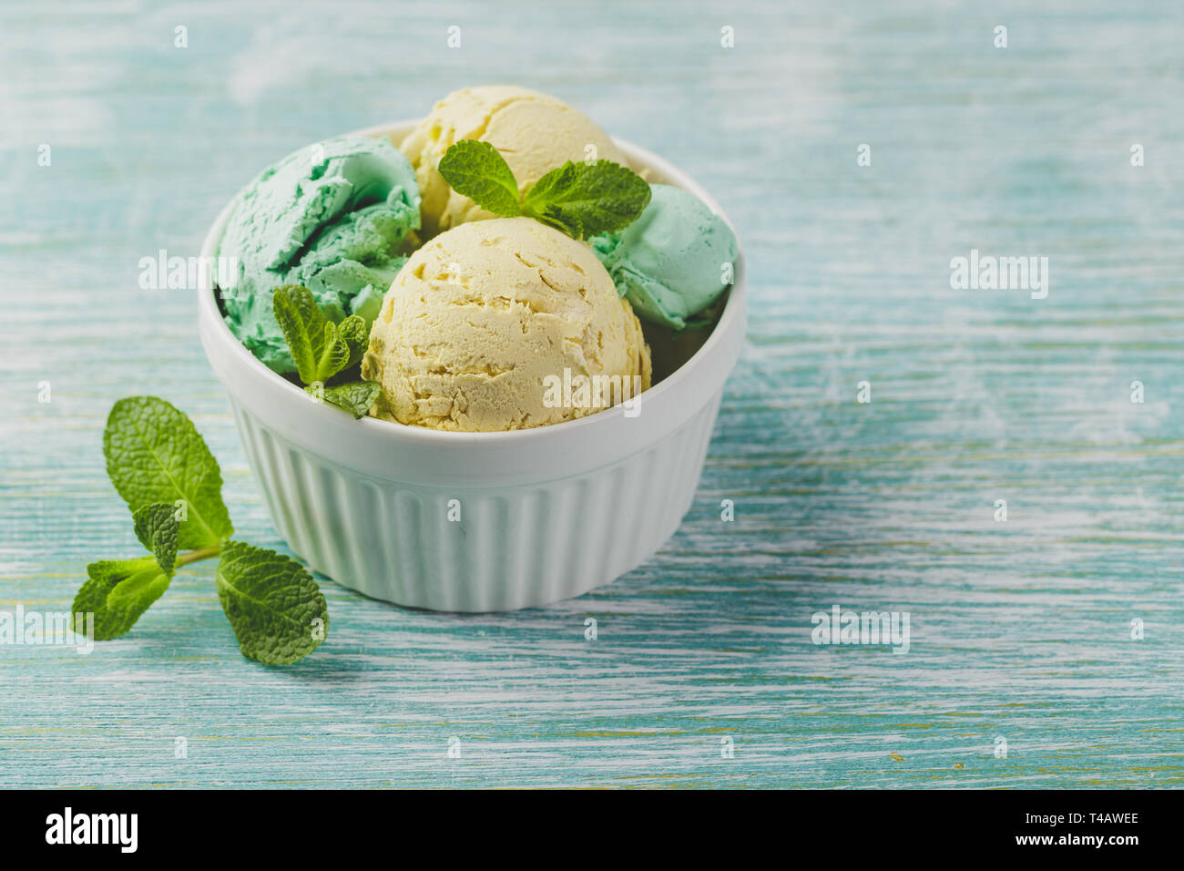 Minze und Zitrone Eis mit Minze in Keramik Schüssel auf grünen Holz- Hintergrund Stockfoto