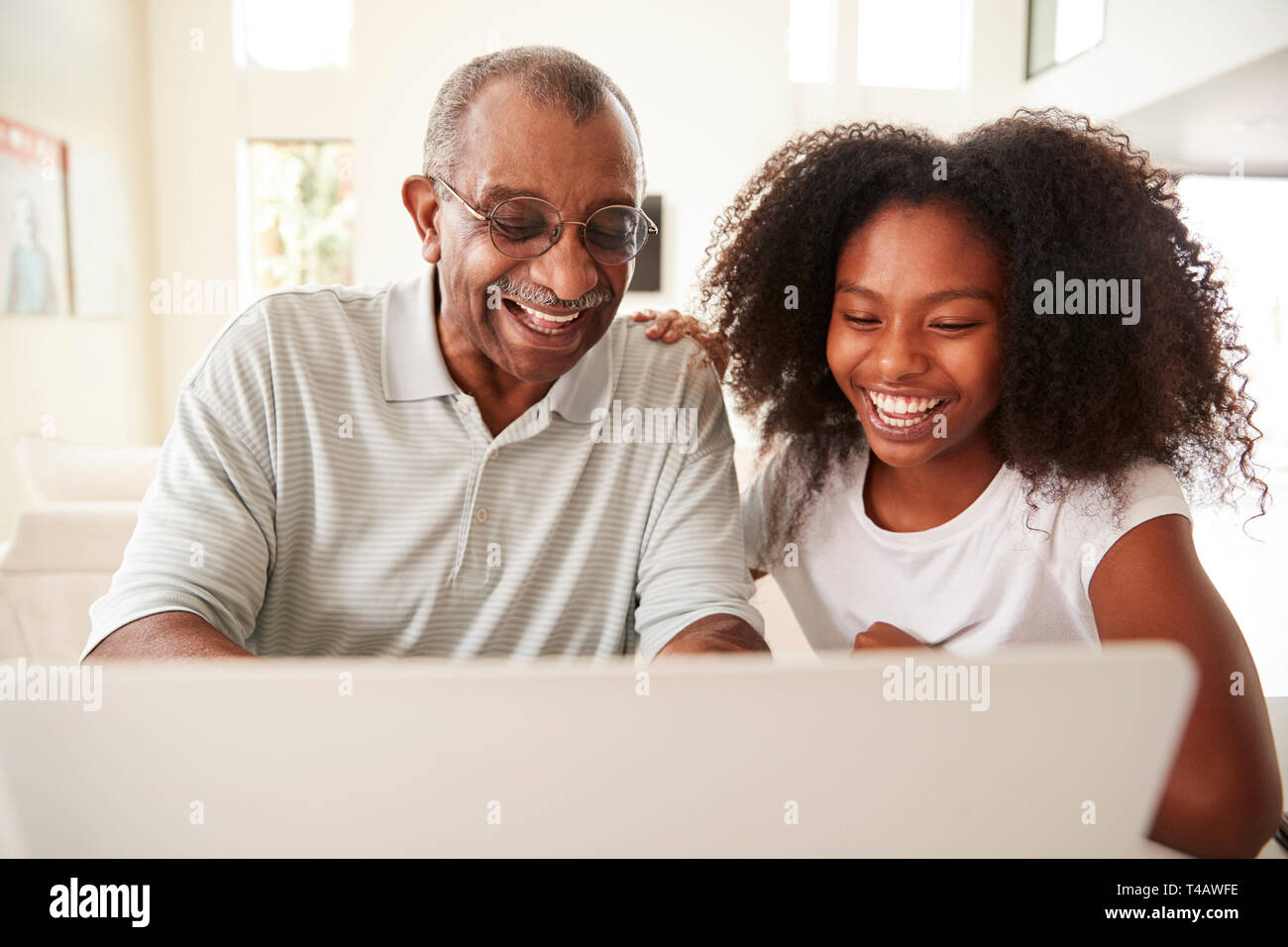 Teenage schwarze Mädchen helfen, ihr Großvater ein Notebook verwenden, Vorderansicht, in der Nähe Stockfoto