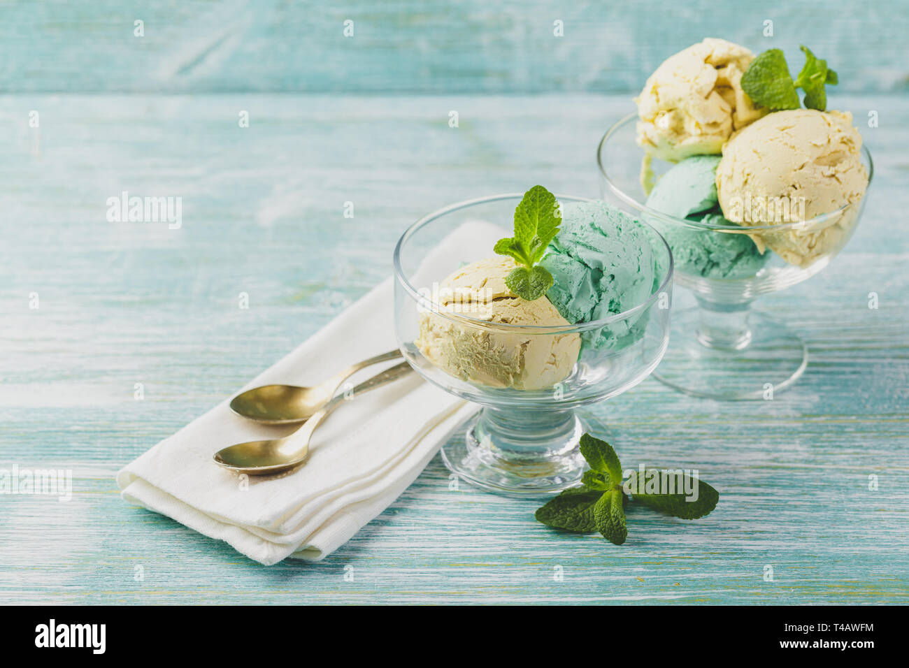 Minze und Zitrone Eis mit Minze im Glas Schüssel auf grünen Holz- Hintergrund Stockfoto