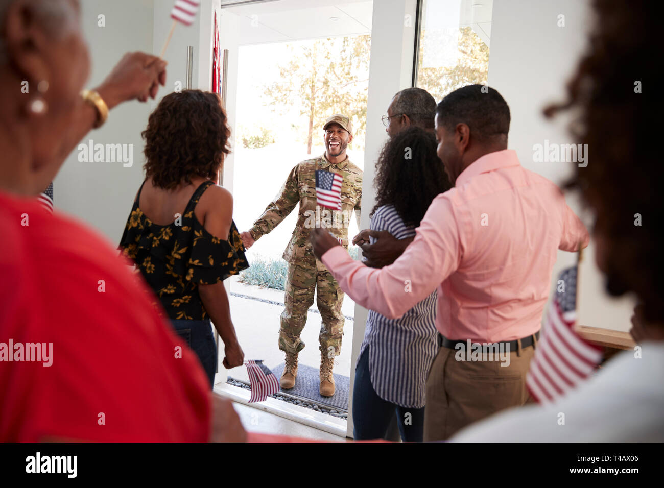 Junge schwarze Soldaten nach Hause zurückkehren, um eine überraschung Familie Partei, selektiver Fokus, über die Schulter sehen Stockfoto