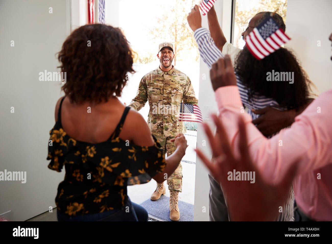 Frau und Familie durch die vordere Tür für junge schwarze Soldaten nach Hause warten, bis in der Nähe Stockfoto