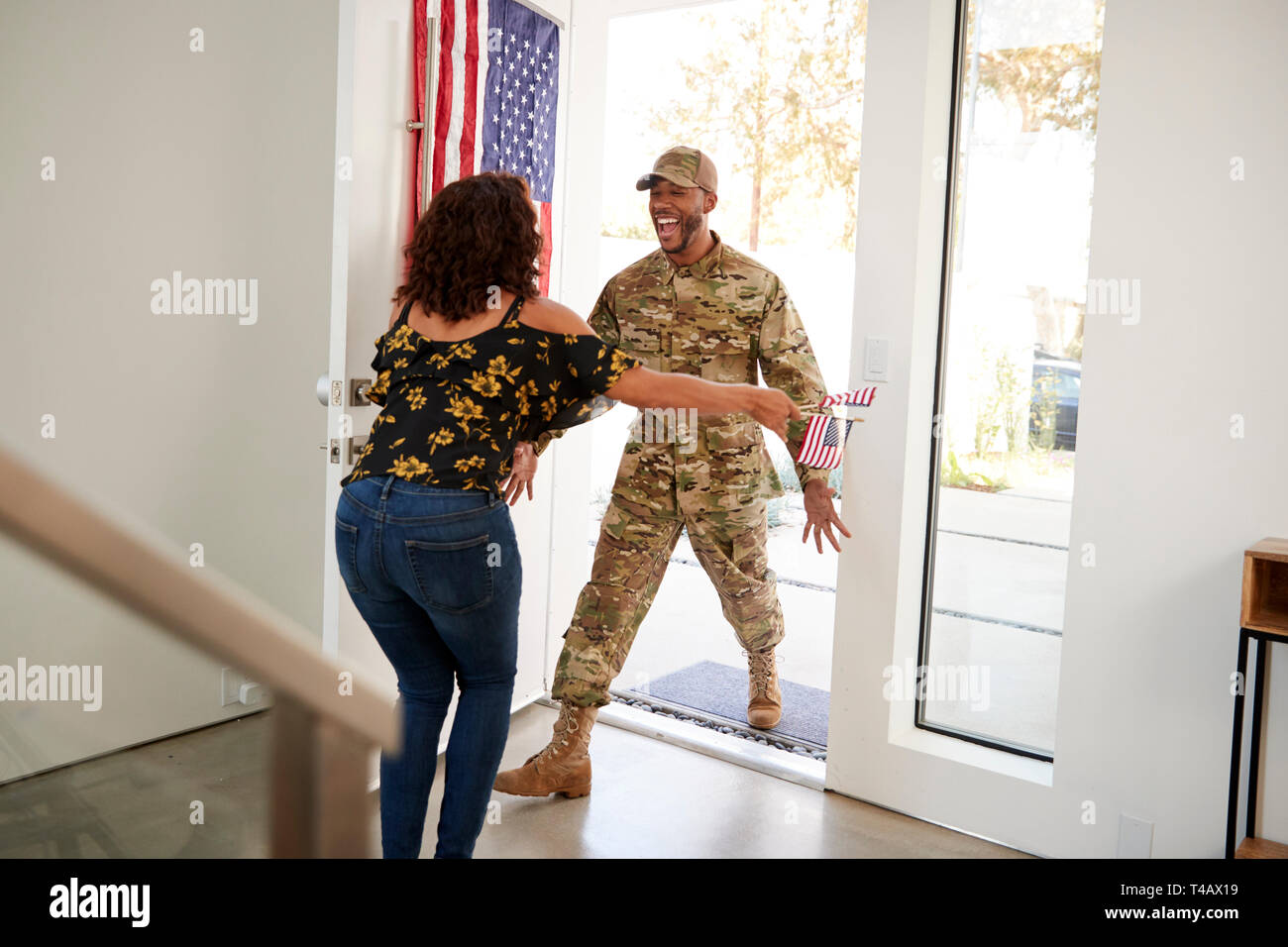 Tausendjährige männlichen schwarzen Soldaten die Heimkehr in die Arme seiner Frau öffnen, schließen Stockfoto