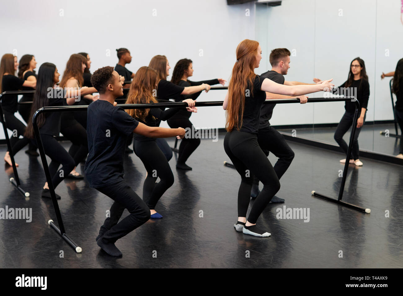 Schüler mit Lehrer an der Performing Arts School Proben Ballett im Tanzstudio mit Barre Stockfoto