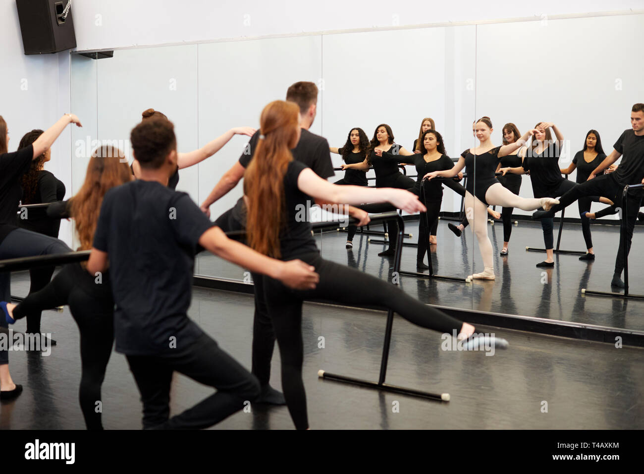 Männliche und weibliche Kursteilnehmer an der Performing Arts School Proben Ballett im Tanzstudio mit Barre Stockfoto