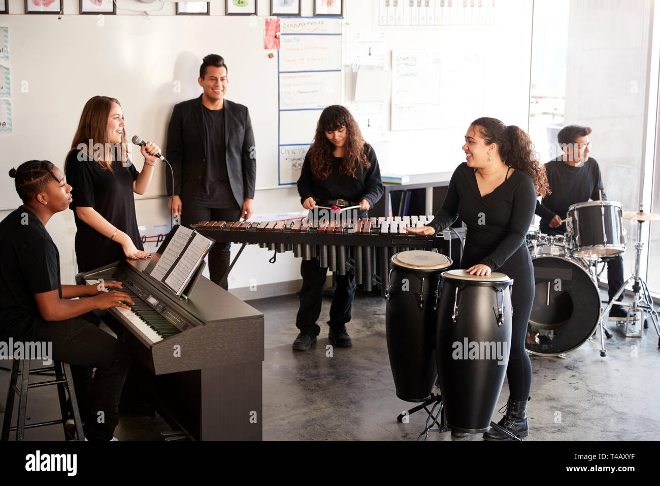 Studenten an der Schule für darstellende Künste spielen In Band bei Proben mit Lehrer Stockfoto