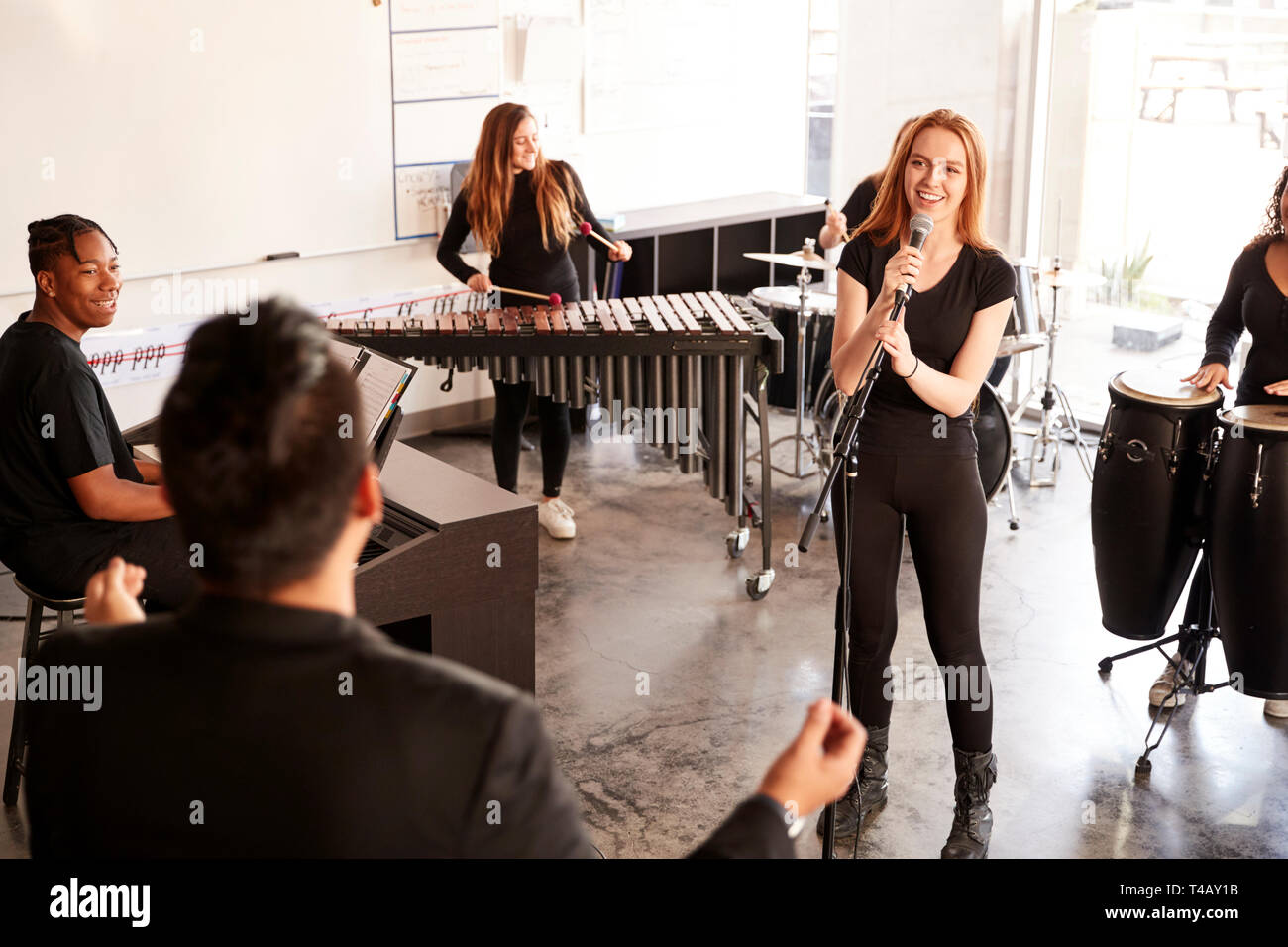 Studenten an der Schule für darstellende Künste spielen In Band bei Proben mit Lehrer Stockfoto