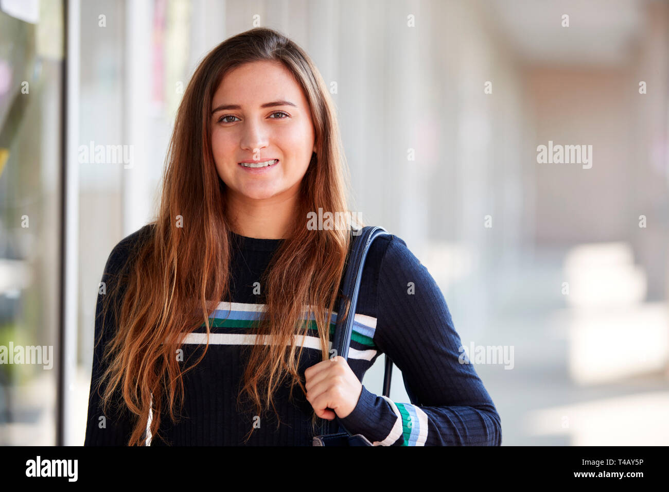 Portrait von Lächelnd weibliche Studenten mit Rucksack im Flur des Gebäudes Stockfoto