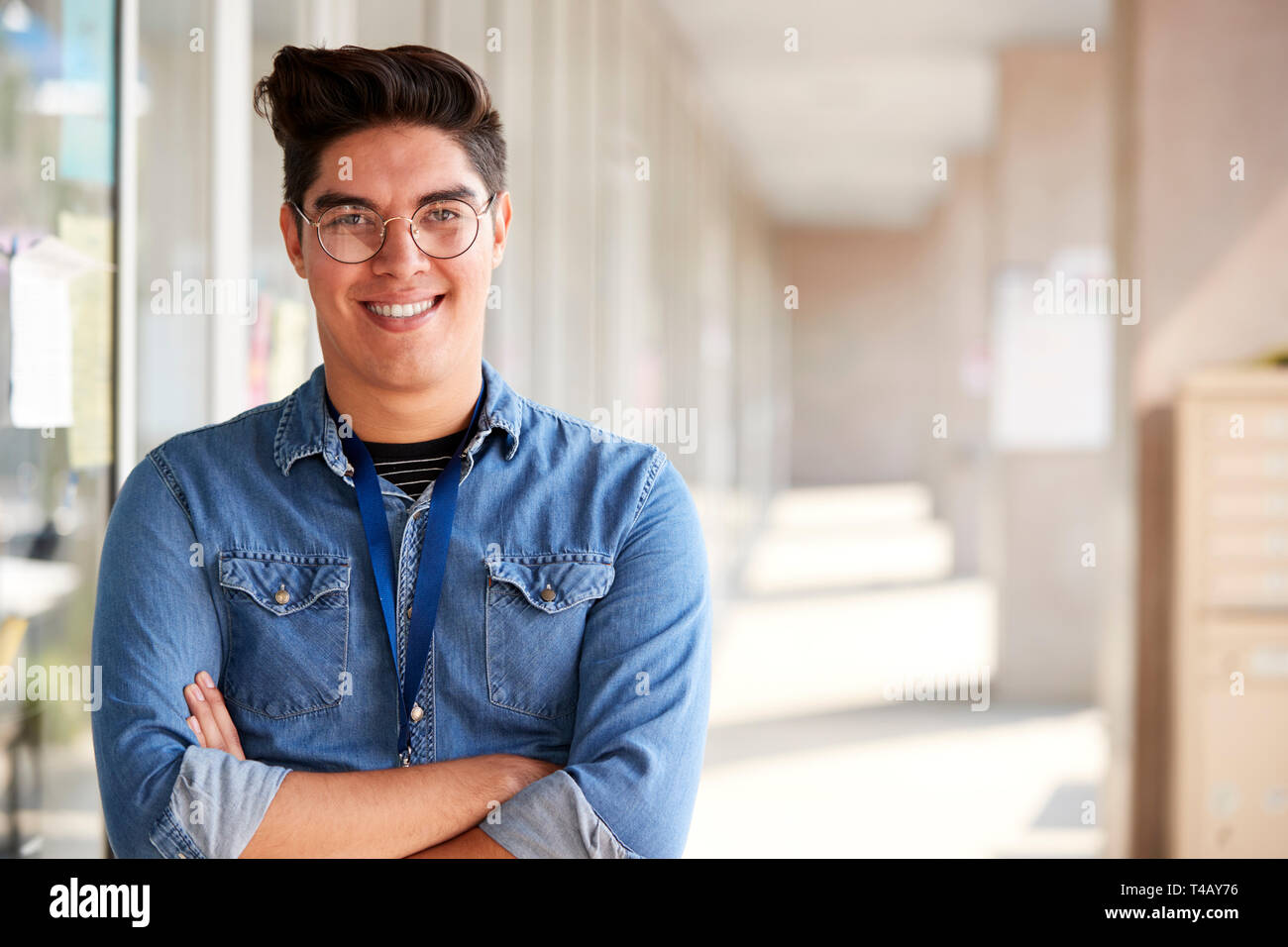 Portrait von lächelnden Männliche Lehrer stehen im Korridor der Hochschule Gebäude Stockfoto