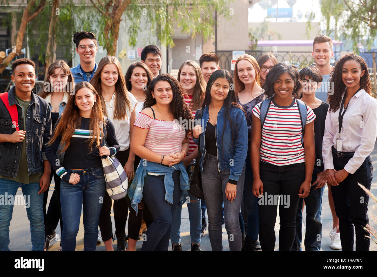 Portrait von lächelnden Männliche und weibliche Studenten mit Lehrer außerhalb der Schule Gebäude Stockfoto