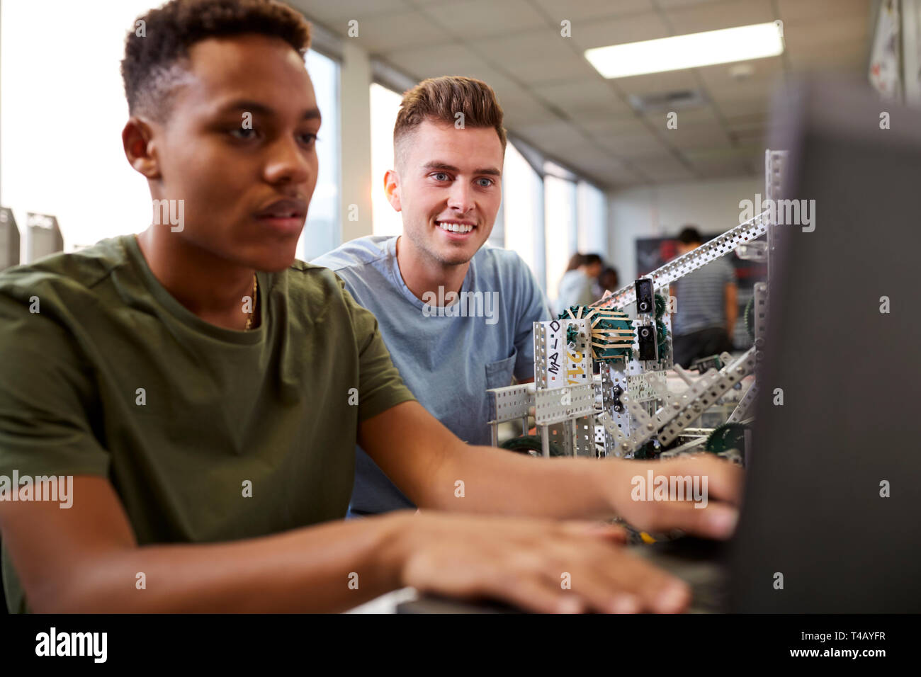 Zwei männliche Studierende Gebäude Maschine in der Wissenschaft Robotik oder Technische Klasse Stockfoto