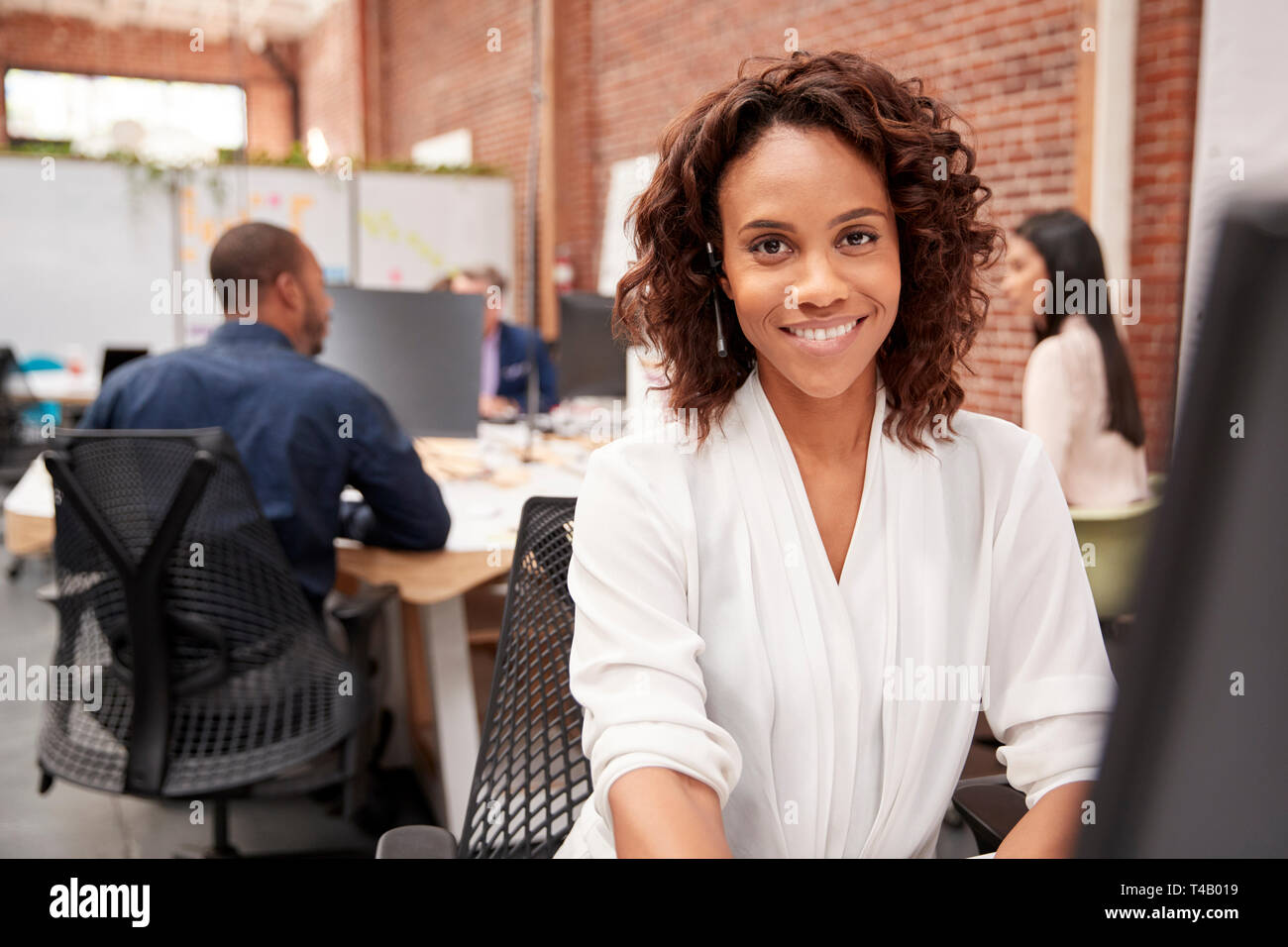 Portrait der weiblichen Kunden Services Agent Arbeiten am Schreibtisch in Call Center Stockfoto