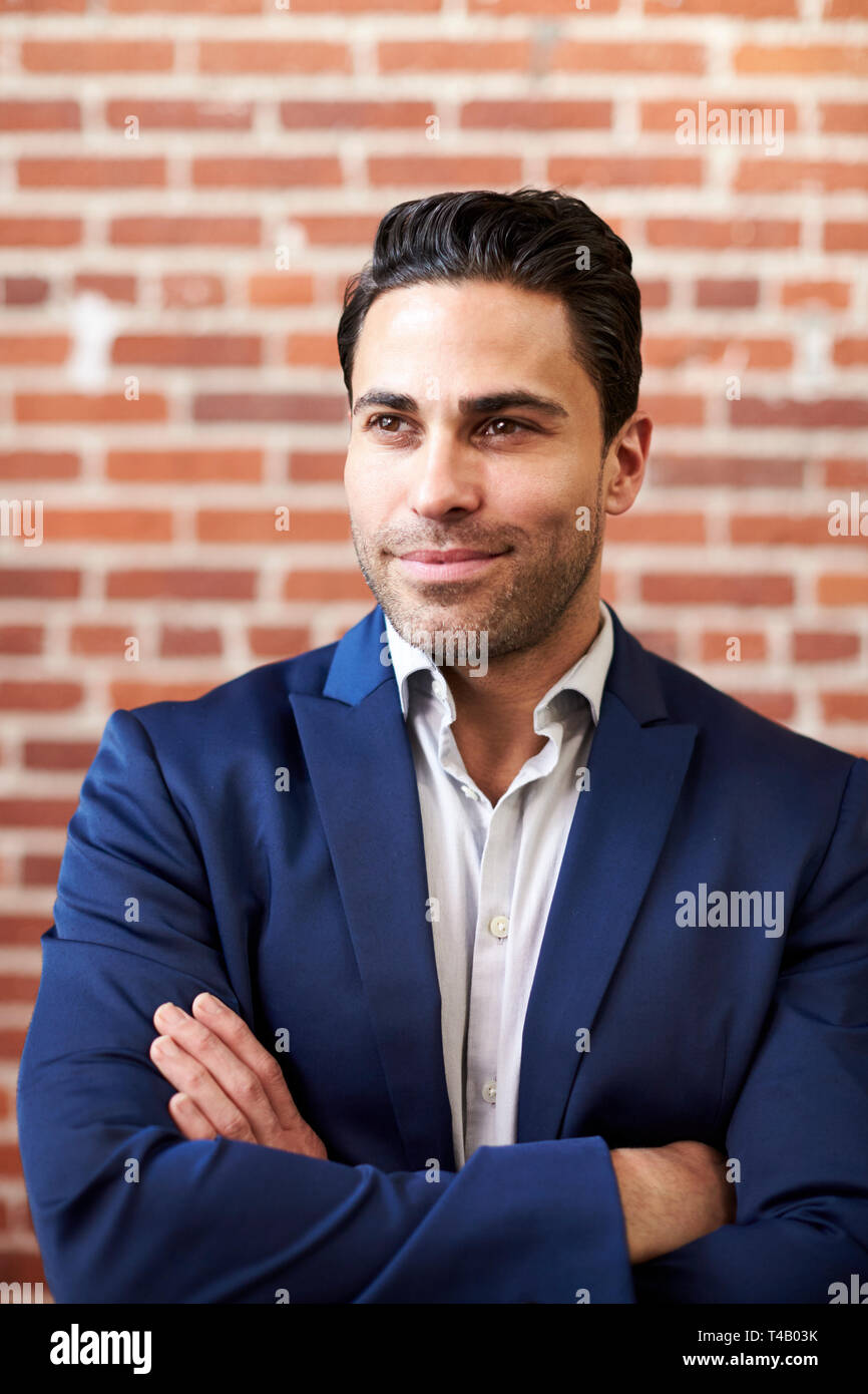 Lächelnd Reife Geschäftsmann gegen Mauer stehend in modernen Büro Stockfoto
