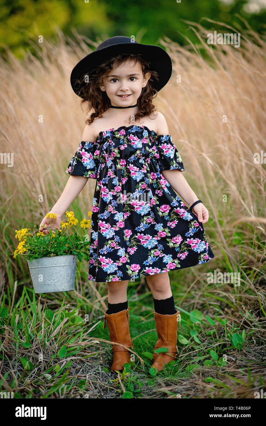 Junge Mädchen in Hut und Stiefel im hohen Gras Feld Stockfoto