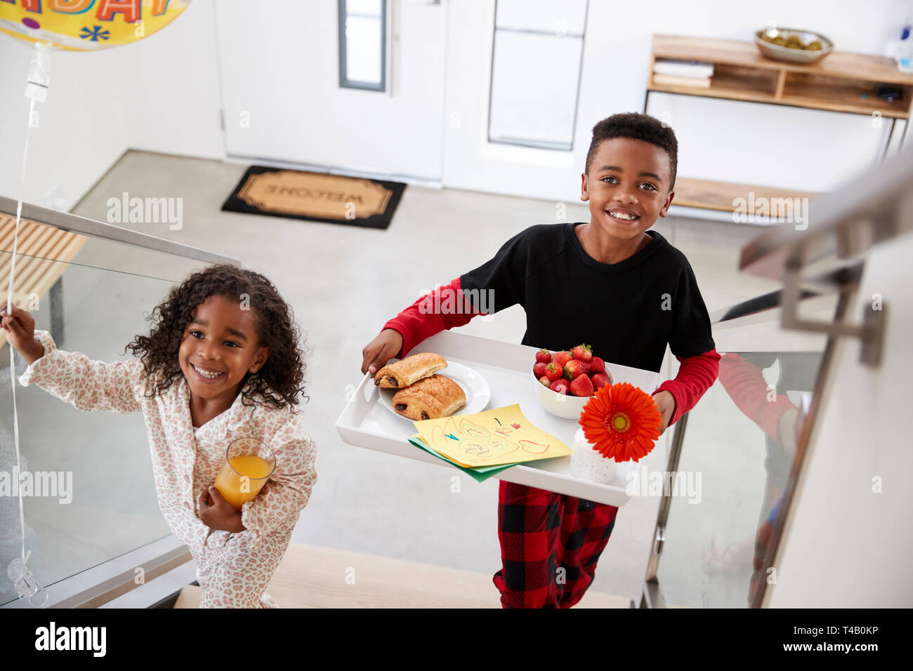 Kinder, die ihre Eltern ein Frühstück im Bett von Fach zu Geburtstag Muttertag Väter feiern Tag Stockfoto