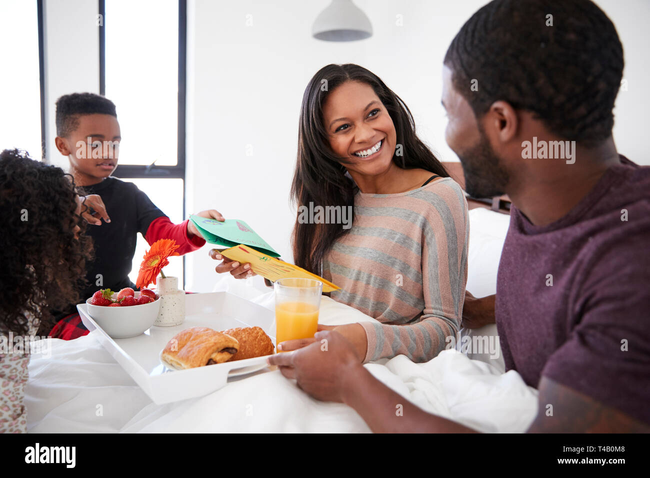 Kinder, die ihre Mutter Frühstück im Bett zu feiern Muttertag oder Geburtstag Stockfoto