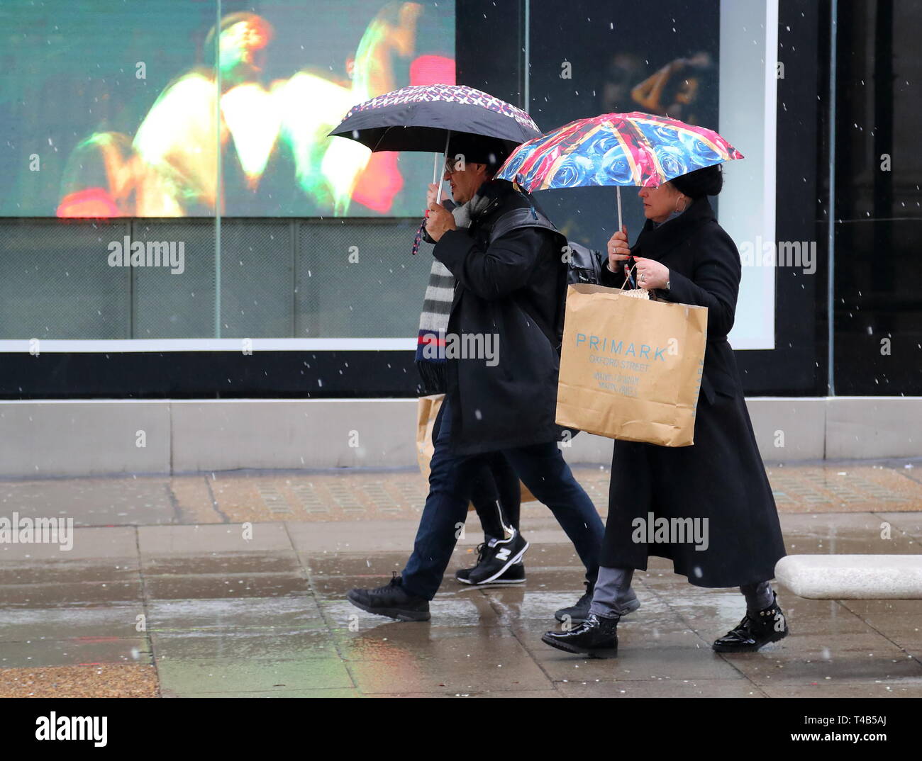 Käufer Sonnenschirme im Regen in der Oxford Street, London, UK Stockfoto