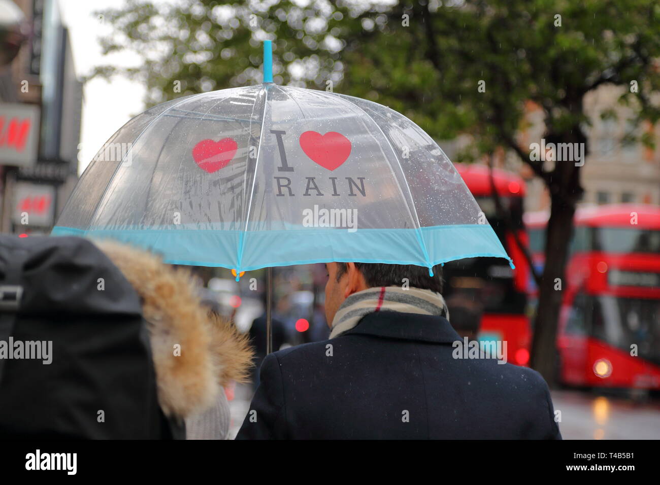 Käufer Sonnenschirme im Regen in der Oxford Street, London, UK Stockfoto