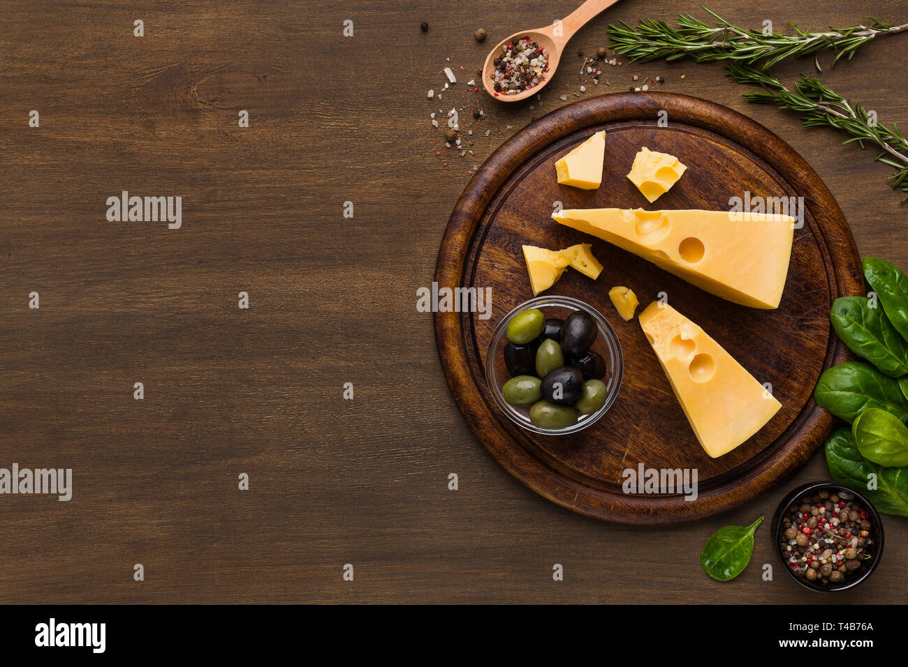 Käse, Oliven und frischen Kräutern auf Holz- Hintergrund. Stockfoto