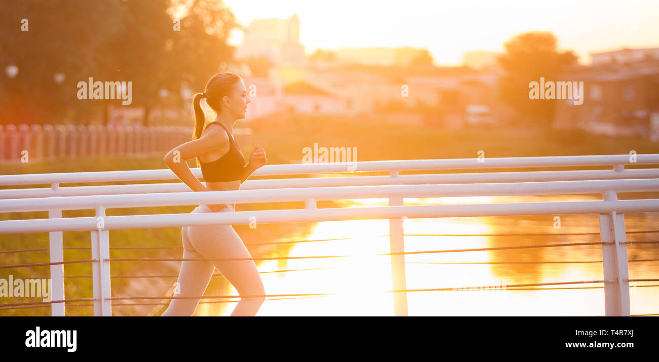 Pretty Woman Athlet läuft auf Brücke, Sonnenlicht Stockfoto