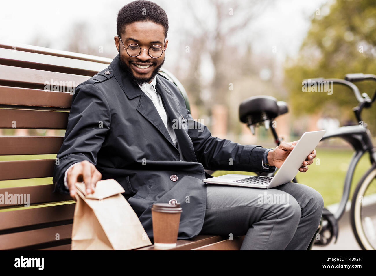 Keine Zeit für die Pause. Junge Unternehmer mit Laptop im Freien Stockfoto