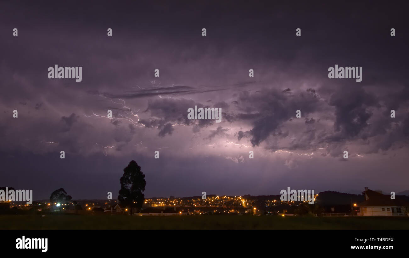 Starke Gewitter im dunkel lila Himmel über der Stadt Sao Jose dos Pinhais, Parana, Brasilien Stockfoto