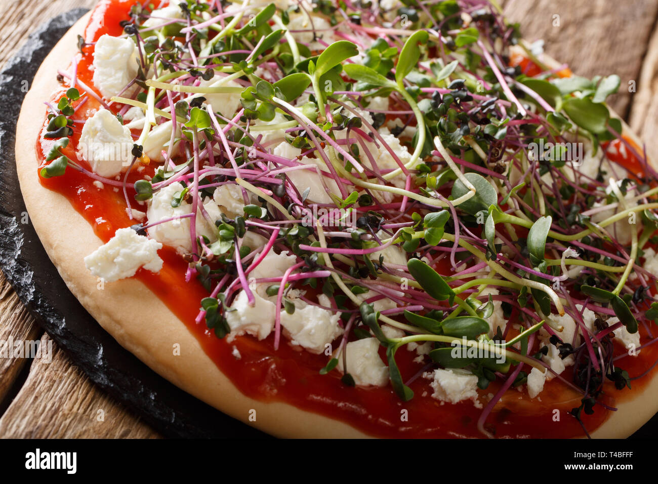Hausgemachte Pizza mit Feta und Mix microgreen Close-up auf dem Tisch. Horizontale Stockfoto
