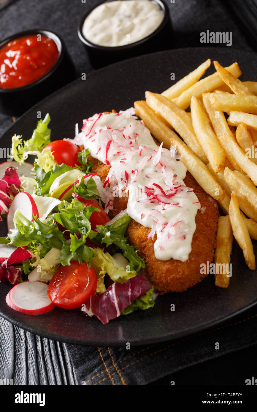 Gebratene Pollock in Panade mit Pommes Frites und Salat close-up auf einem Teller auf den Tisch. Vertikale Stockfoto