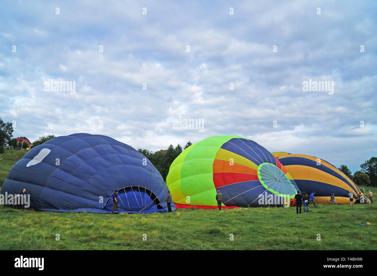 Luftballons in Rot, Blau, Gelb, Grün und Orange aufgeblasen vor dem Aufstieg in den Himmel auf einem Green Glade Stockfoto