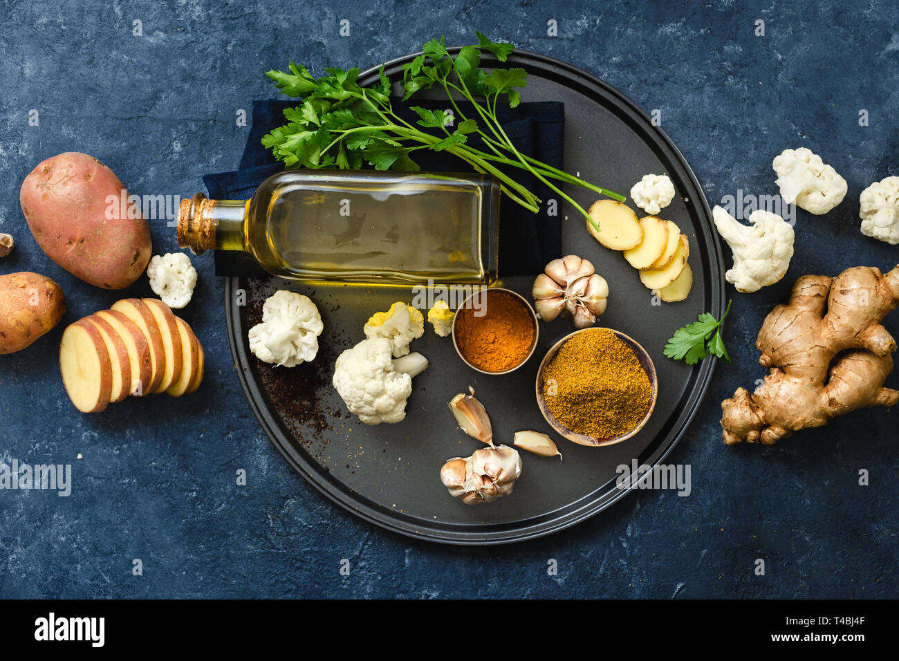Zutaten kochen Aloo Gobi indisches Essen auf dunklem Stein Hintergrund Stockfoto