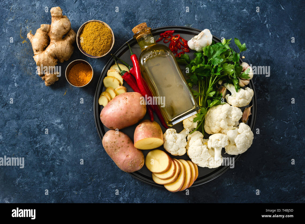 Zutaten kochen Aloo Gobi indisches Essen auf dunklem Stein Hintergrund Stockfoto