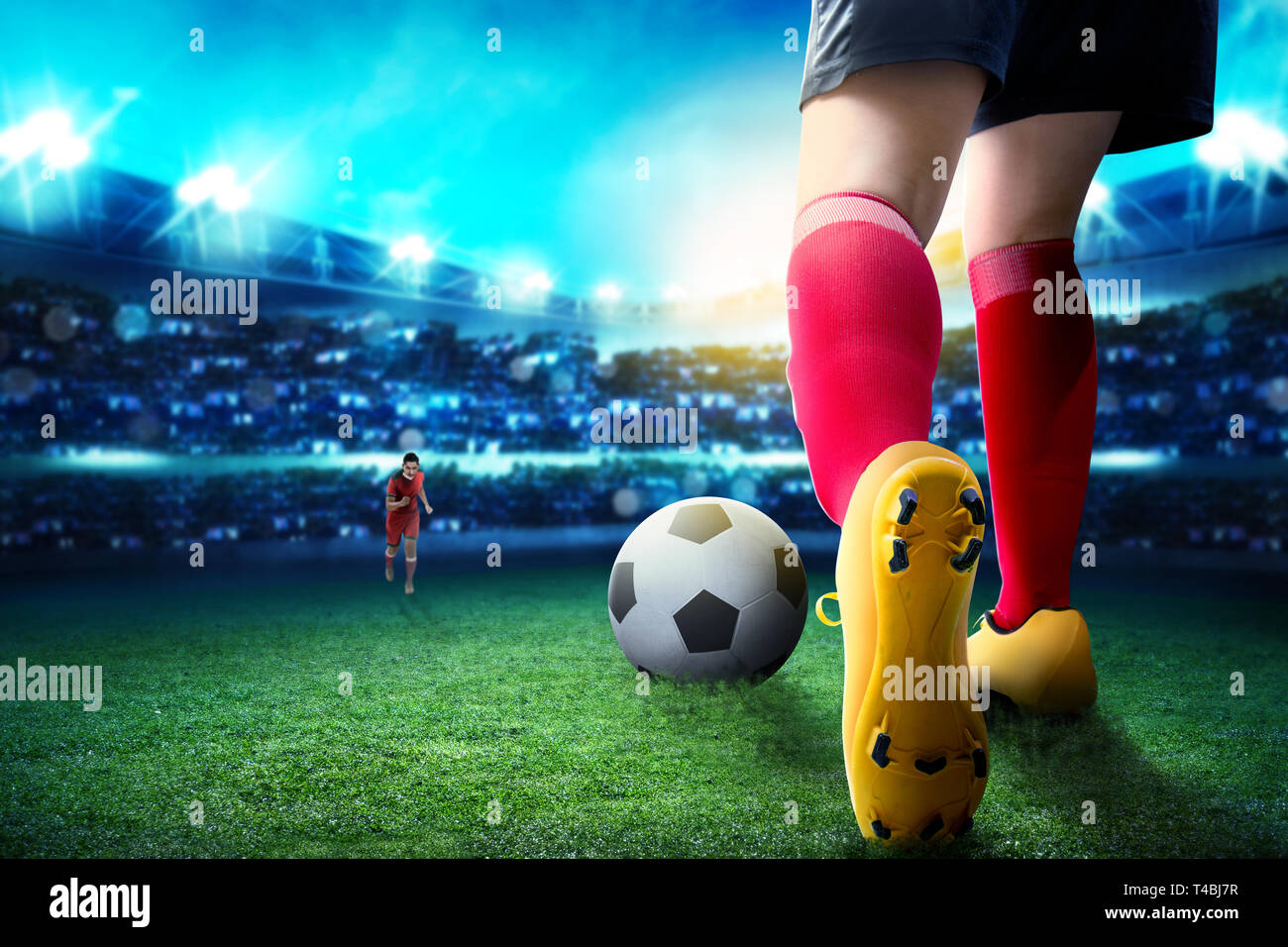 Ansicht der Rückseite des Fußball-Spieler Frau Dribbling den Ball auf und den Umgang mit ihrer Gegnerin auf dem Fußballfeld bei Stadion Stockfoto