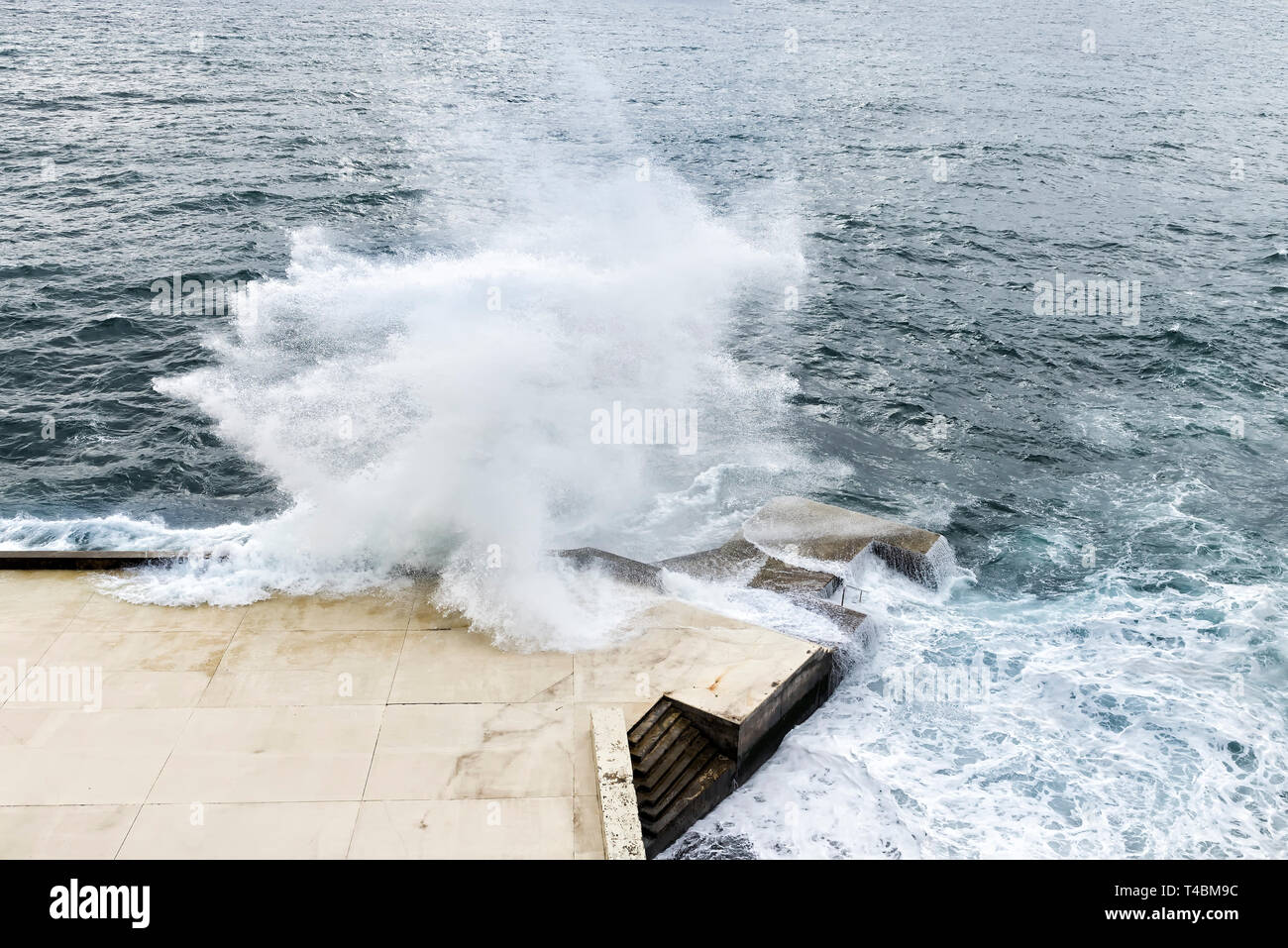 Wellen gegen die Promenade Stockfoto