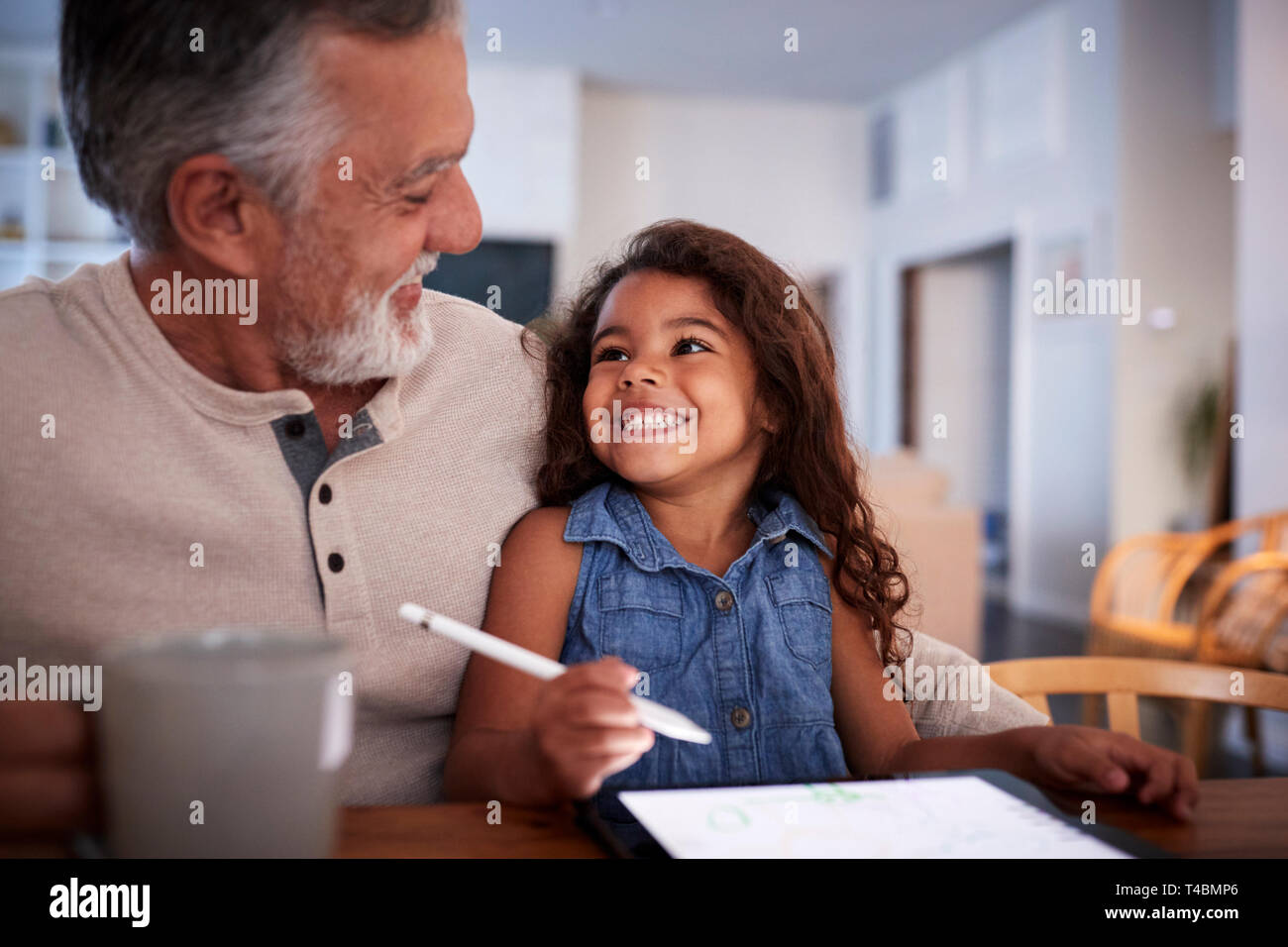 Senior Hispanic Mann mit seiner Enkelin auf Tablet Computer, an einander suchen, Nahaufnahme Stockfoto