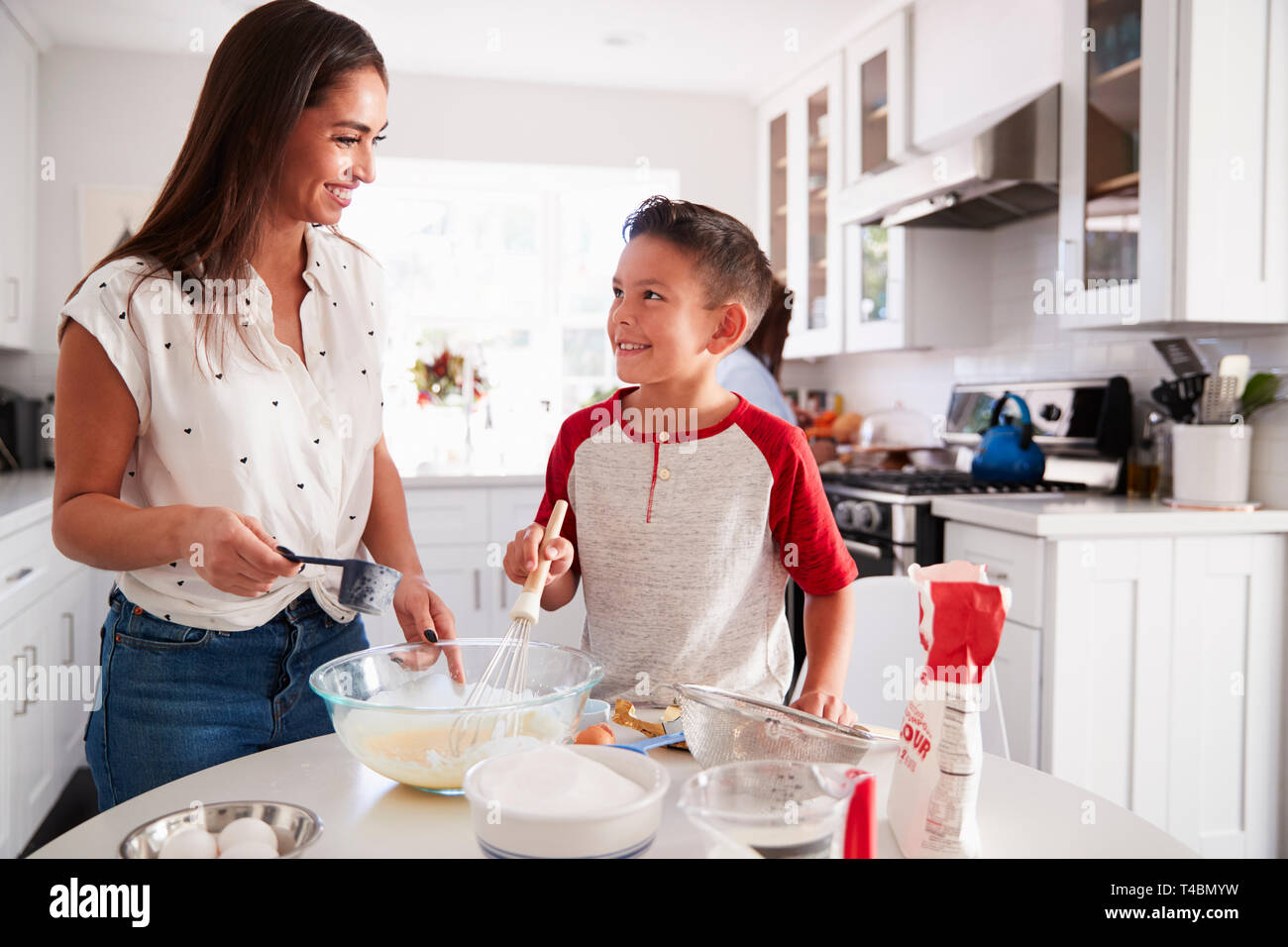 Pre-teen Boy einen Kuchen in der Küche mit seiner Mama, an einander suchen, Nahaufnahme Stockfoto