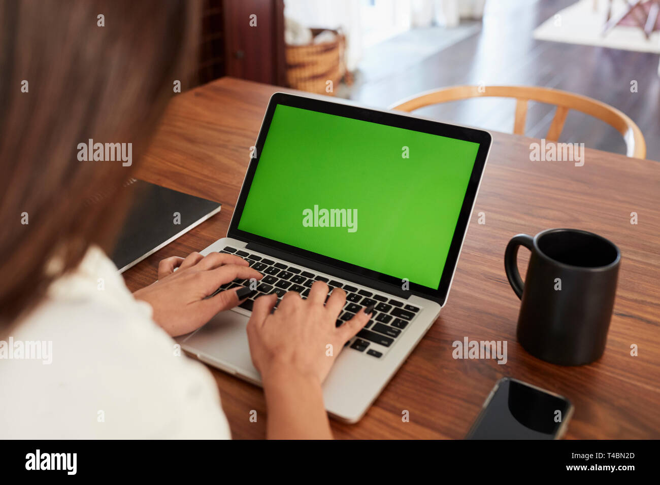 Blick über die Schulter der Frau am Tisch sitzt mit Laptop Computer zu Hause, in der Nähe Stockfoto