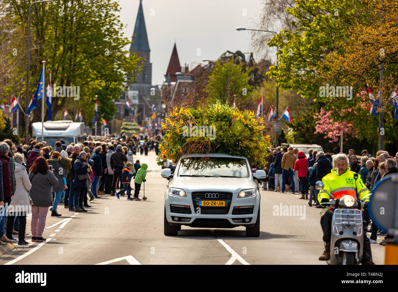 Ein Auto mit schönen Blumen und viele Zuschauer bei der jährlichen bloemencorso Glühlampe Blumenkorso in der hoofdstraat in der niederländischen Dorf Sassenhei Stockfoto