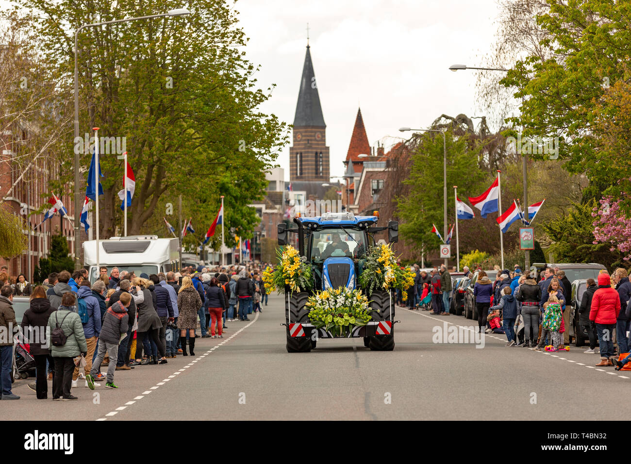 Ein Traktor mit wunderschönen Blumen und viele Zuschauer bei der jährlichen bloemencorso Glühlampe Blumenkorso in der hoofdstraat in der niederländischen Dorf Sass Stockfoto