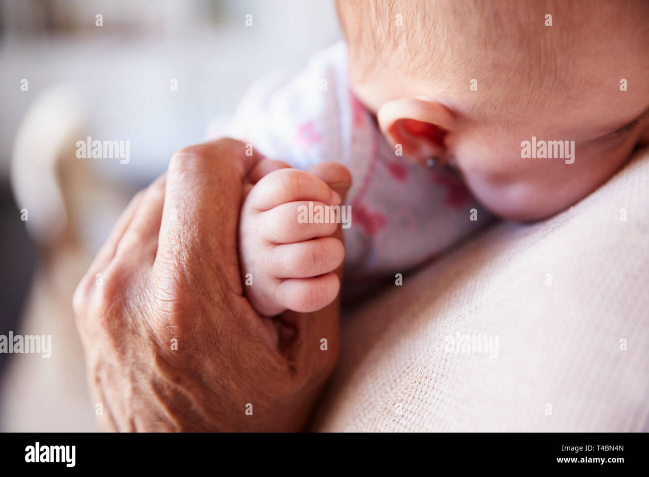 Nahaufnahme von Großvater die Hand seines Babys Enkel, als er ihn hält, Detail, Ansicht Stockfoto