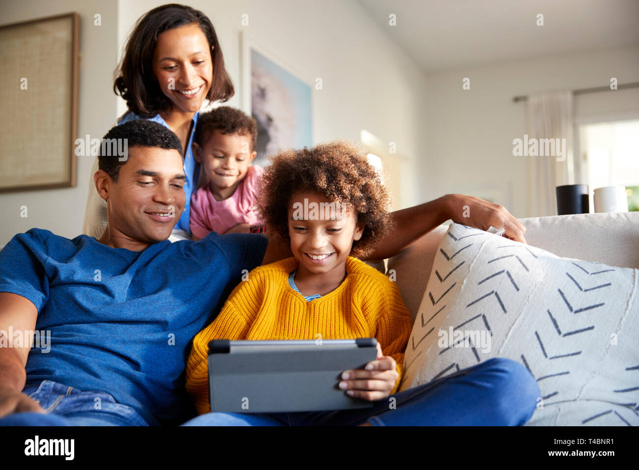 Junge Familie Zeit miteinander zu verbringen mit einem Tablet-PC in Ihrem Wohnzimmer, Vorderansicht Stockfoto