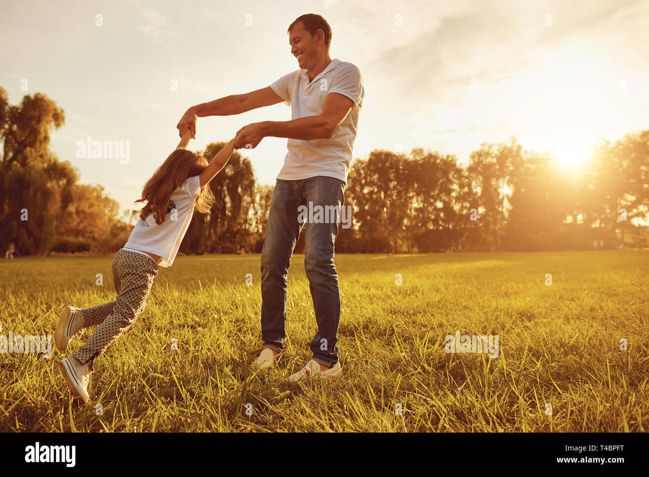 Glückliche junge Vater plauing mit Kind draußen im Park. Stockfoto