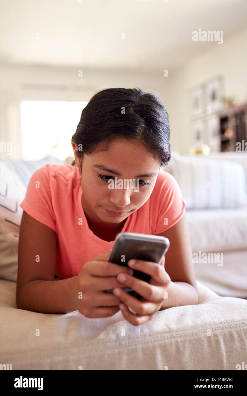 Teenager auf dem Sofa zu Hause im Wohnzimmer mit Smartphone, Nahaufnahme, niedrig, Winkel, vertikal Stockfoto