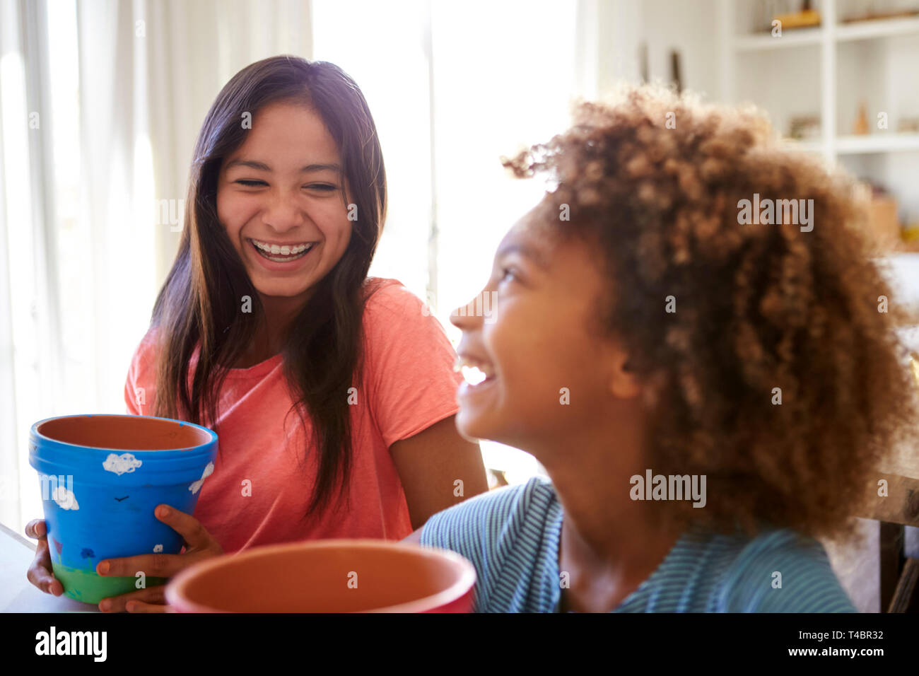 Lachend vor - jugendlich Mädchen und ihre ältere Freundin, Blumentöpfe, dass Sie mit Farben zu Hause, selektiven Fokus eingerichtet haben, in der Nähe Stockfoto