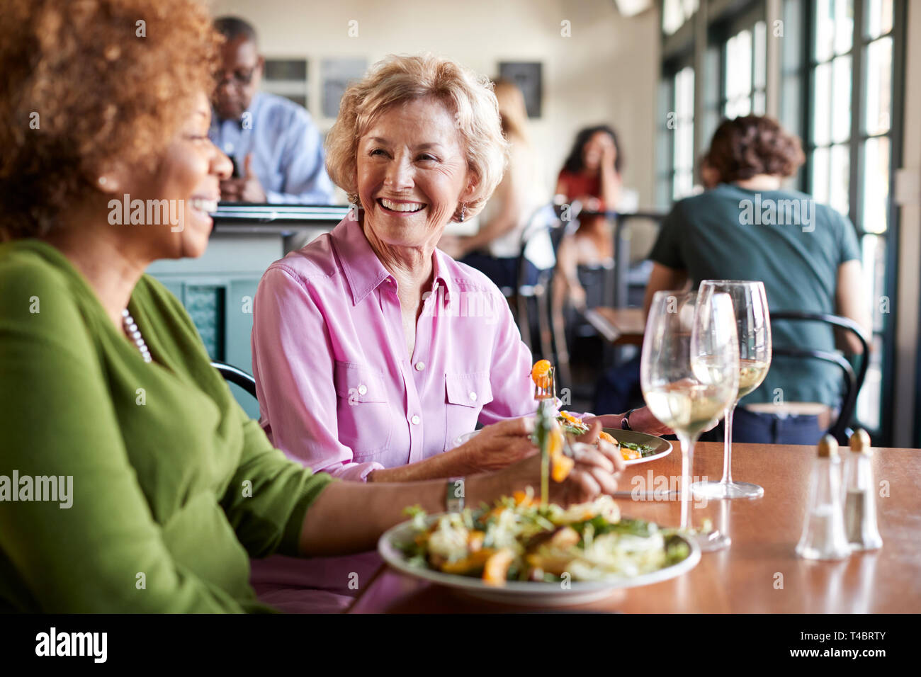 Zwei lächelnde ältere Frauen Treffen für Abendessen in Restaurant Stockfoto