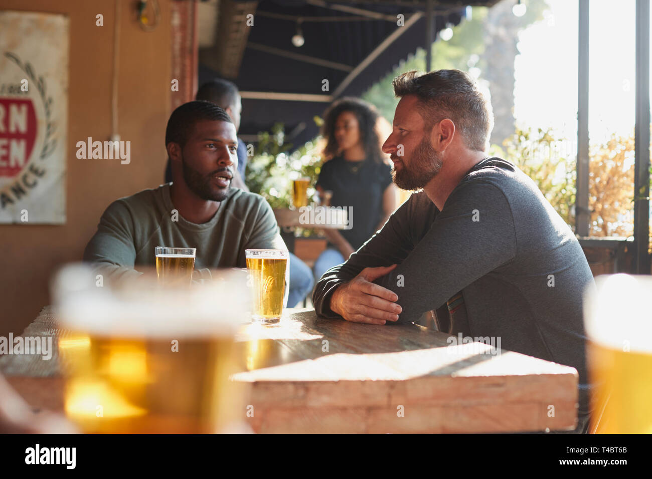 Zwei männliche Freunde treffen im Sport Bar mit Getränk vor dem Spiel Stockfoto