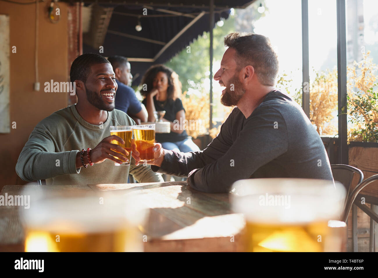 Zwei männliche Freunde treffen in Sports Bar, Toast zusammen Stockfoto