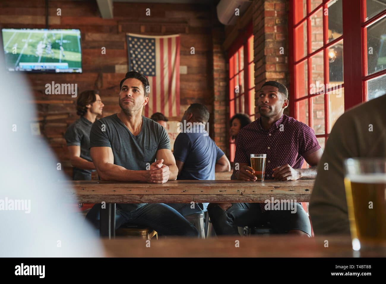 Männliche Freunde Bier trinken und Wildbeobachtung auf dem Bildschirm In der Sports Bar Stockfoto