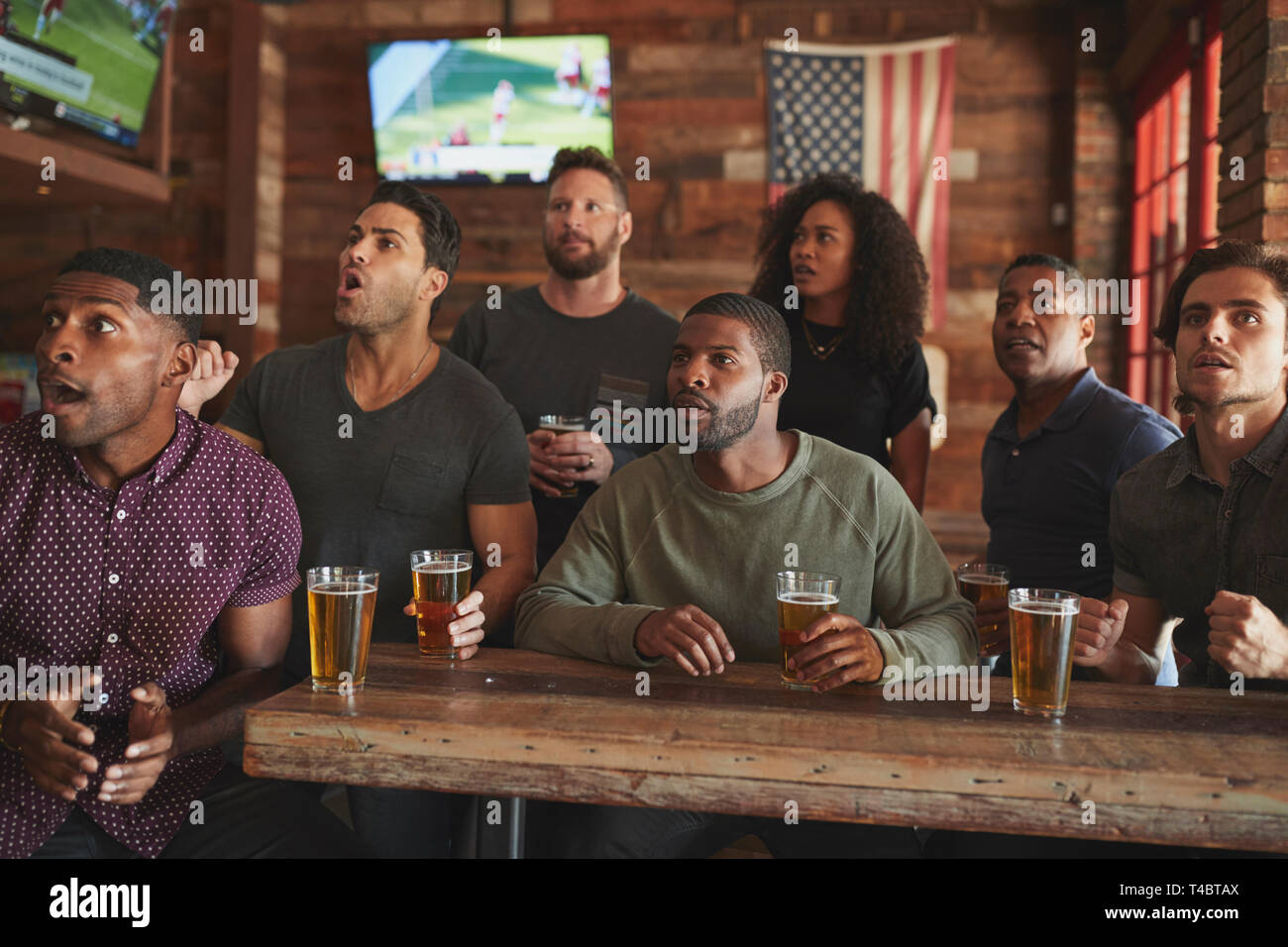 Gruppe von Freunden Wildbeobachtung auf dem Bildschirm In der Sports Bar Stockfoto
