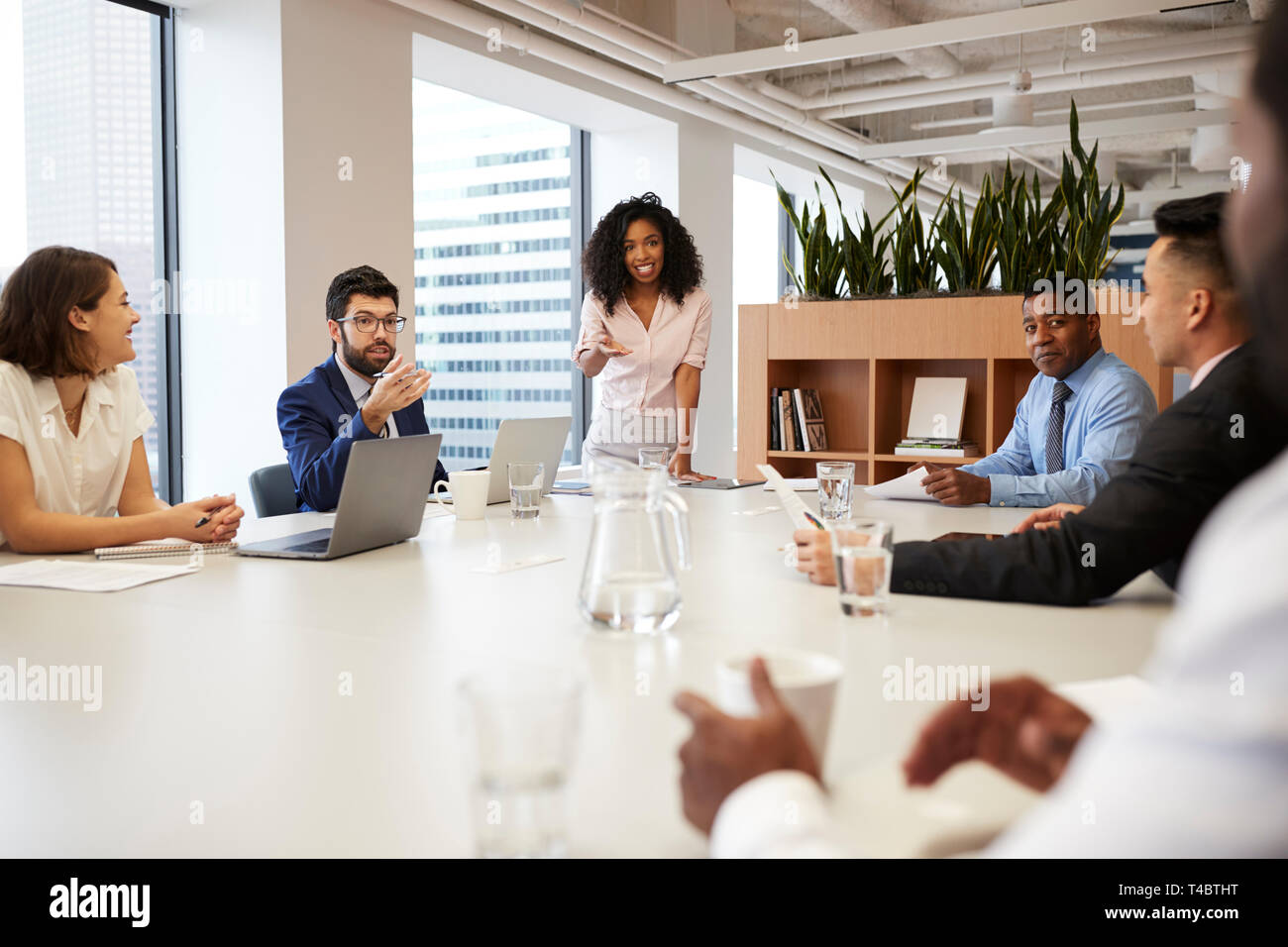 Geschäftsfrau steht eine Präsentation halten zu Kollegen in modernen Großraumbüro Stockfoto