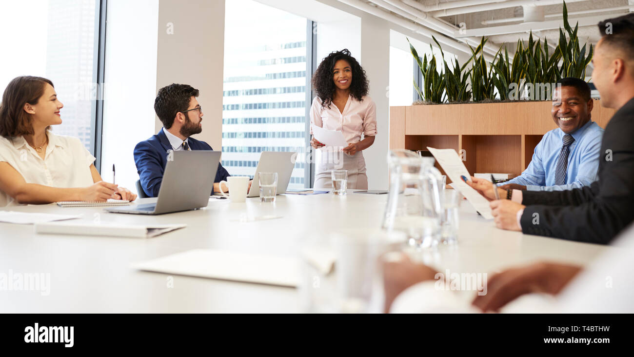 Geschäftsfrau steht eine Präsentation halten zu Kollegen in modernen Großraumbüro Stockfoto